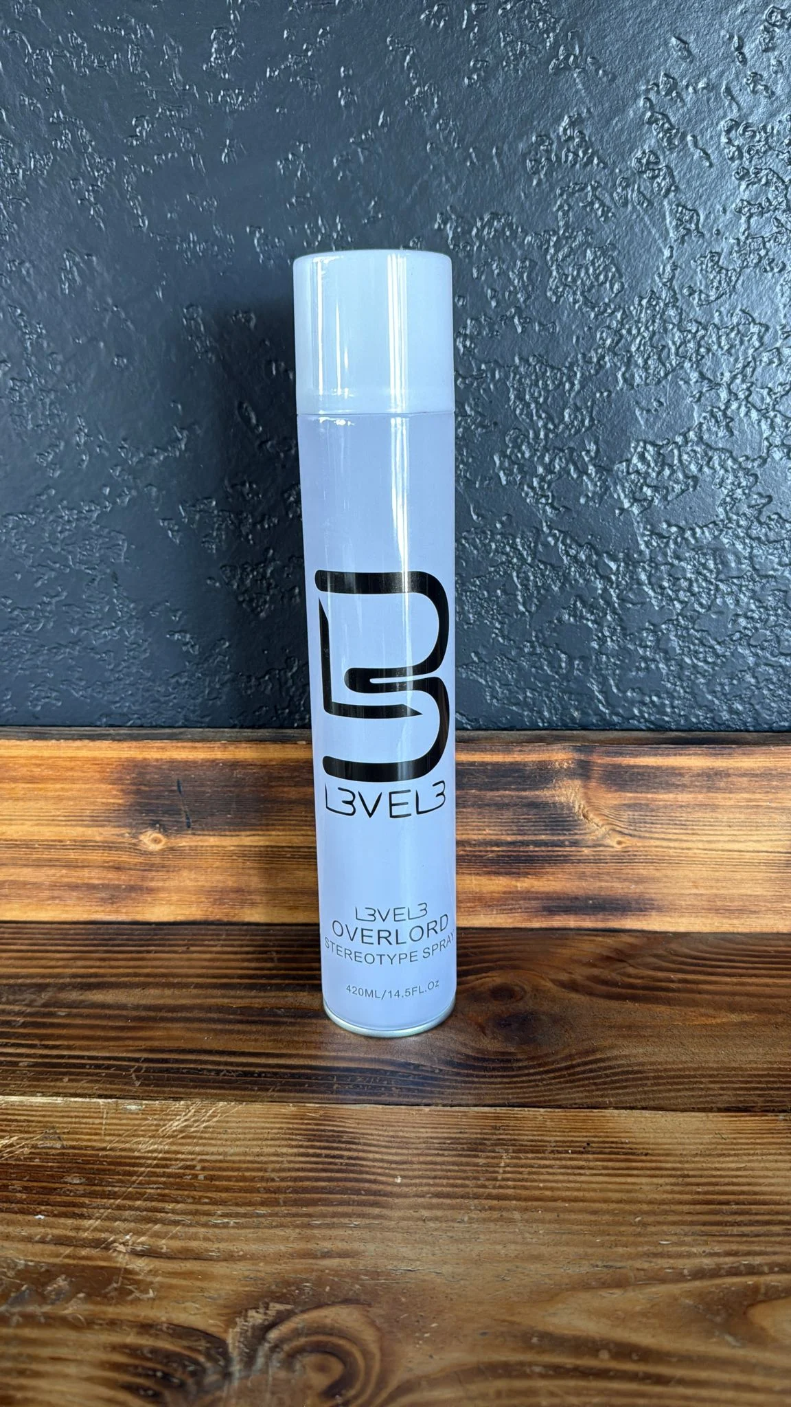 Lata blanca de Level 3 Overlord Spray sobre el mostrador de la barbería